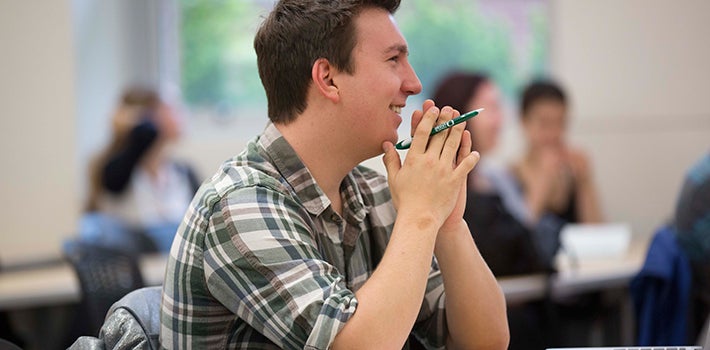 Student smiling in class. Male student smiling in class