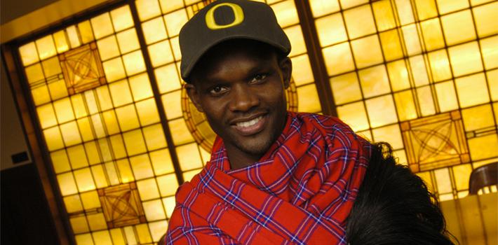 Student proudly wearing an 'O' Student smiling in front of stained glass windows.