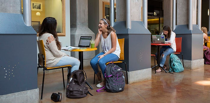 Two Students Laughing Female students sitting, talking, and laughing in the Willamette Hall