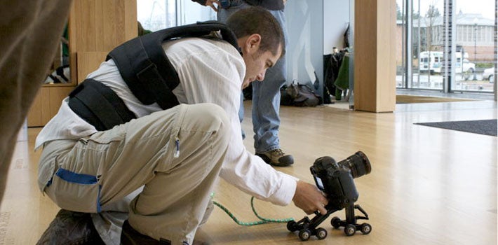 Camera adjustment Man crouches to adjust his camera