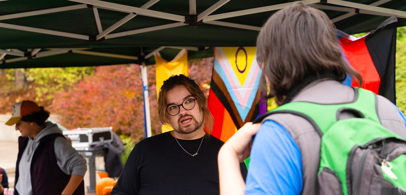Staff member helping a student at an LGBT event