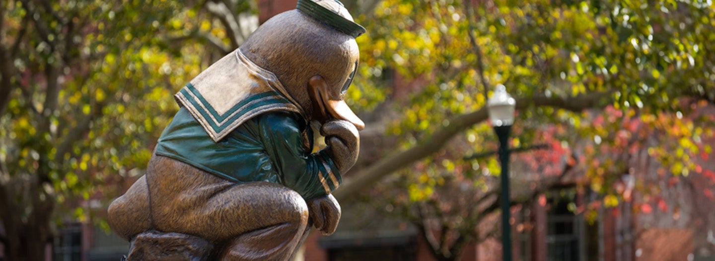 Statue of the UO Duck mascot in a 'Thinker' pose