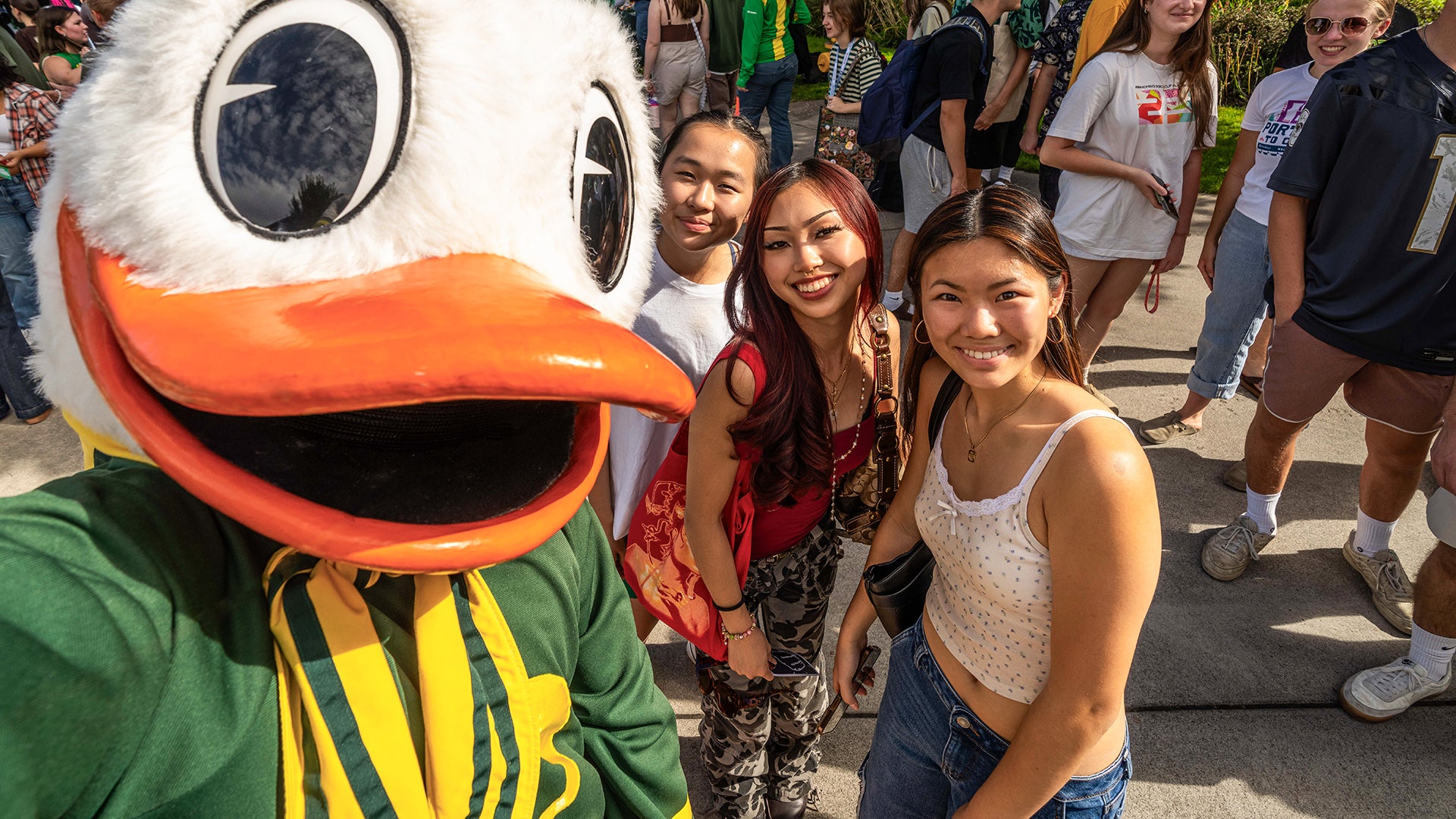 Campus visitors posing for outdoor selfie with UO Duck