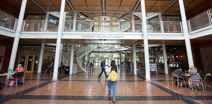 Female student with a yellow back pack and red shoes walking into the Lillis Complex