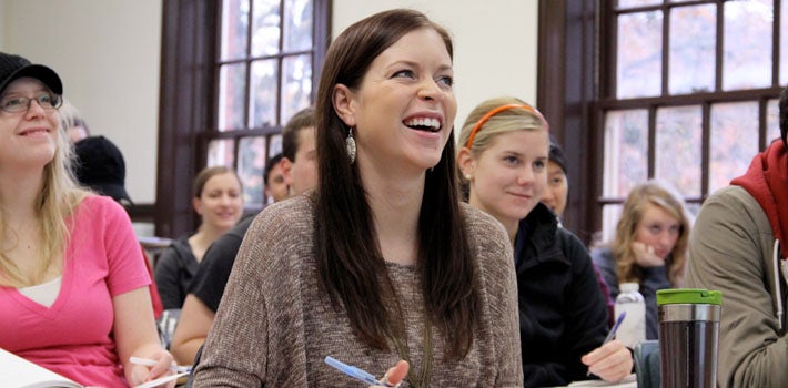 Several students smiling and speaking in German class.