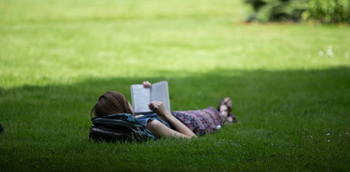 Female student reading in the grass
