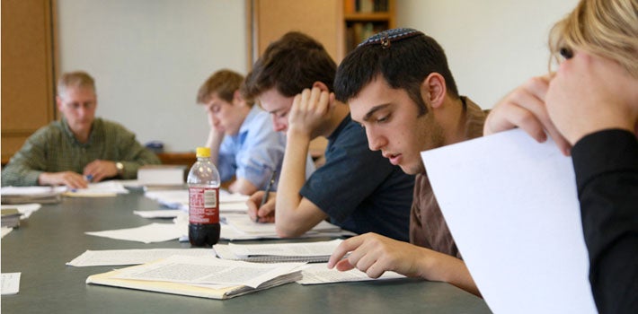Several students pore over their notes in a discussion class.