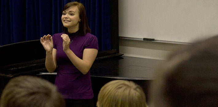 A woman instructs a music class.