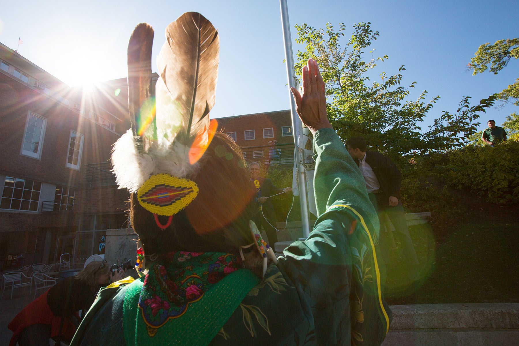 Elder blessing flag raising at EMU ampitheater